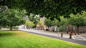 A street lined with trees and buildings, a grassy area, and a clear path. - Dromroe Village University of Limerick (Limerick)