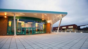 A modern building with a glass facade and a curved roof structure. - Dromroe Village University of Limerick (Limerick)