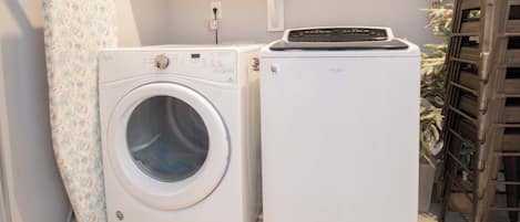 Un espace buanderie équipé d’un lave-linge à chargement frontal et d’un sèche-linge superposé.