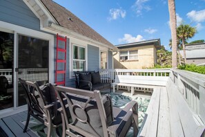 Une terrasse dotée de mobilier d’extérieur, d’une porte-fenêtre coulissante et offrant une vue sur les bâtiments voisins.