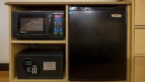 A kitchen with a microwave, a digital coffee maker, and a refrigerator.