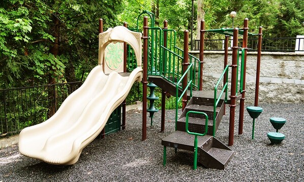 A playground with a slide and climbing structures.