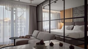 A modern hotel room with a sofa, a small table with a tray, and a bed with white linens. - Vistula View by Fragola Collection (Kraków)