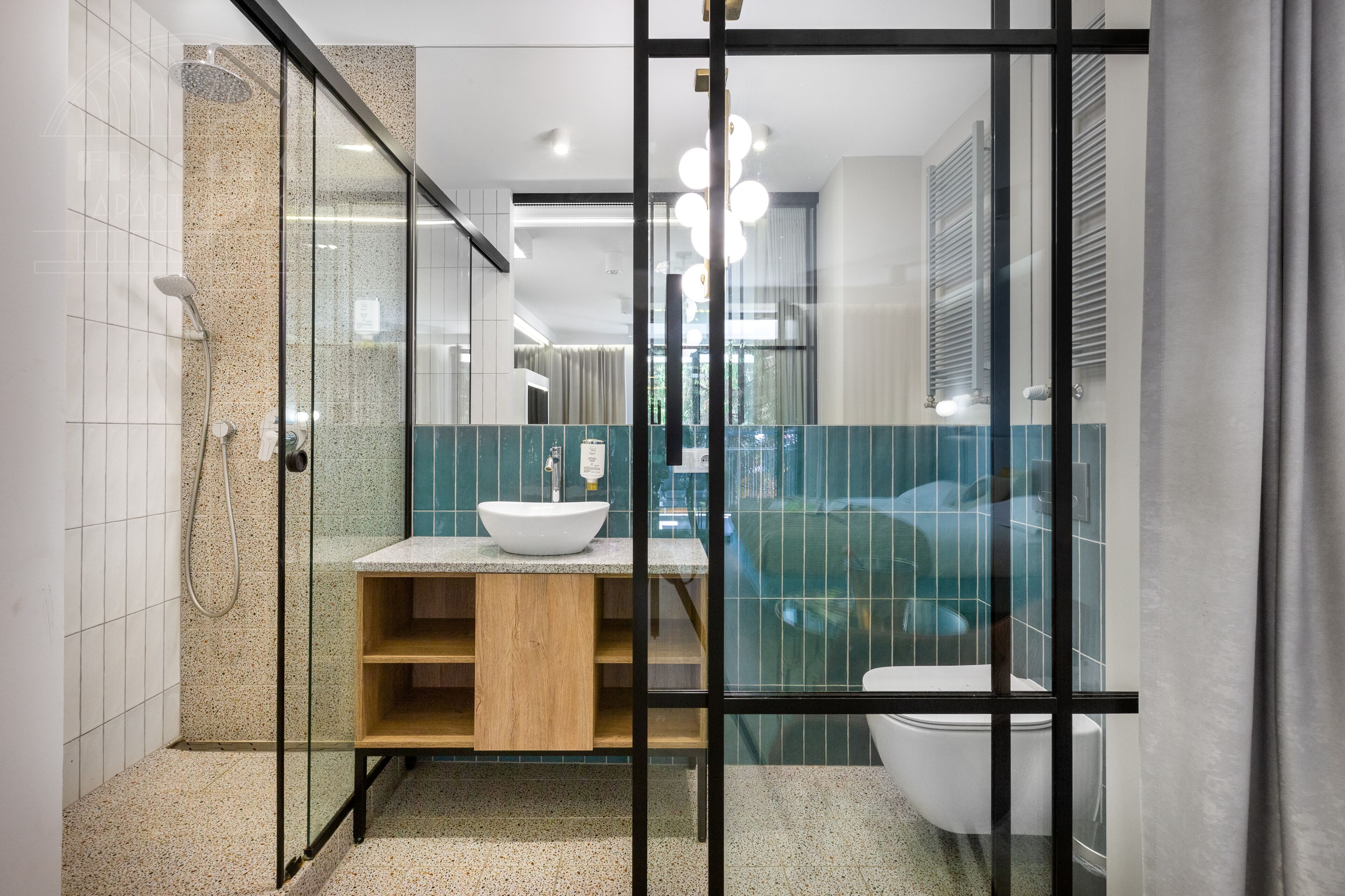 Un baño moderno con ducha de vidrio, lavamanos blanco y retrete.