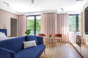 Apartamento luxo, 1 cama Queen, banheiro privativo, vista para o pátio | Área de estar | TV de tela plana