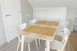 Enjoy meals in this dining area with a table and four chairs, complemented by woven placemats.