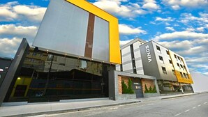 Un bâtiment moderne avec une façade jaune et grise bien visible, de grandes fenêtres et le nom « VINDE’S » inscrit sur le côté.