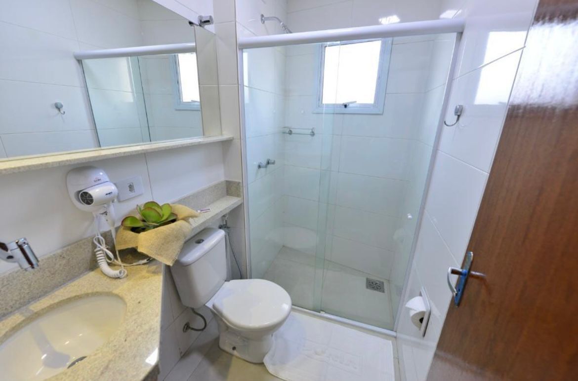 A bathroom with a sink, toilet, and glass-enclosed shower.
