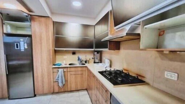 A modern kitchen with wooden cabinets, a stainless steel refrigerator, and a gas stove. - Har nof penthouse (Jerusalem)