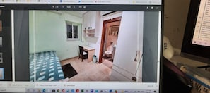 Quarto com cama, escrivaninha e uma pequena janela.