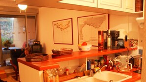 Una cocina con encimera de madera, un lavamanos y diversos utensilios.