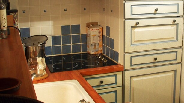 Una cocina con estufa, lavabo y armarios.