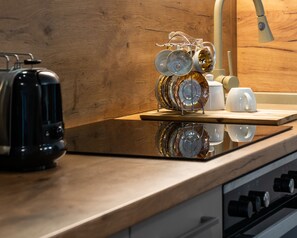 A kitchen counter with a toaster, a dish rack with plates, and a coffee maker. - Vacation Apartment (Wien)