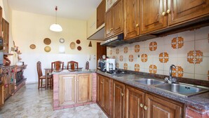 Une cuisine avec des meubles en bois, un îlot central, une cuisinière à gaz et un évier.