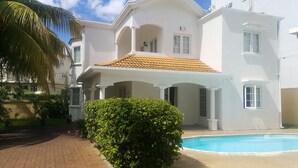 A two-story house with a swimming pool, a covered patio, and a well-maintained garden. - Villa The Golden Dream  (Flic en Flac)