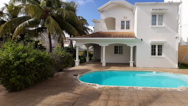 A two-story house with a swimming pool, a covered patio, and a garden with palm trees. - Villa The Golden Dream  (Flic en Flac)