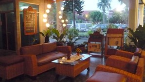 A lobby with a reception desk, seating area, and a view of the street outside. - Hotel Marcopolo (Bandar Lampung)