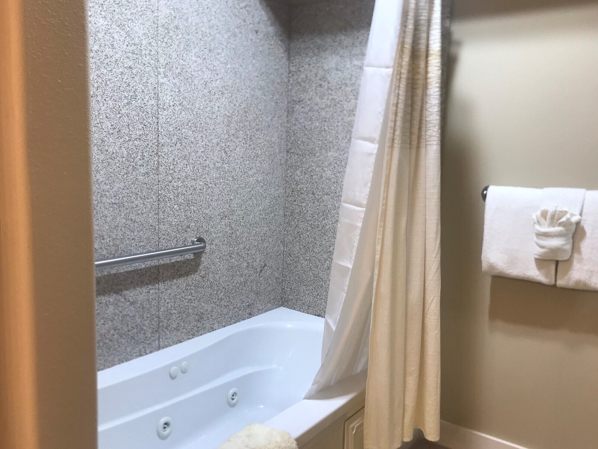 Un baño con bañera, cortina de ducha y un perchero para toallas.