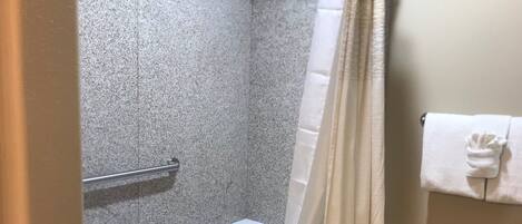 Un baño con bañera, cortina de ducha y un perchero para toallas.