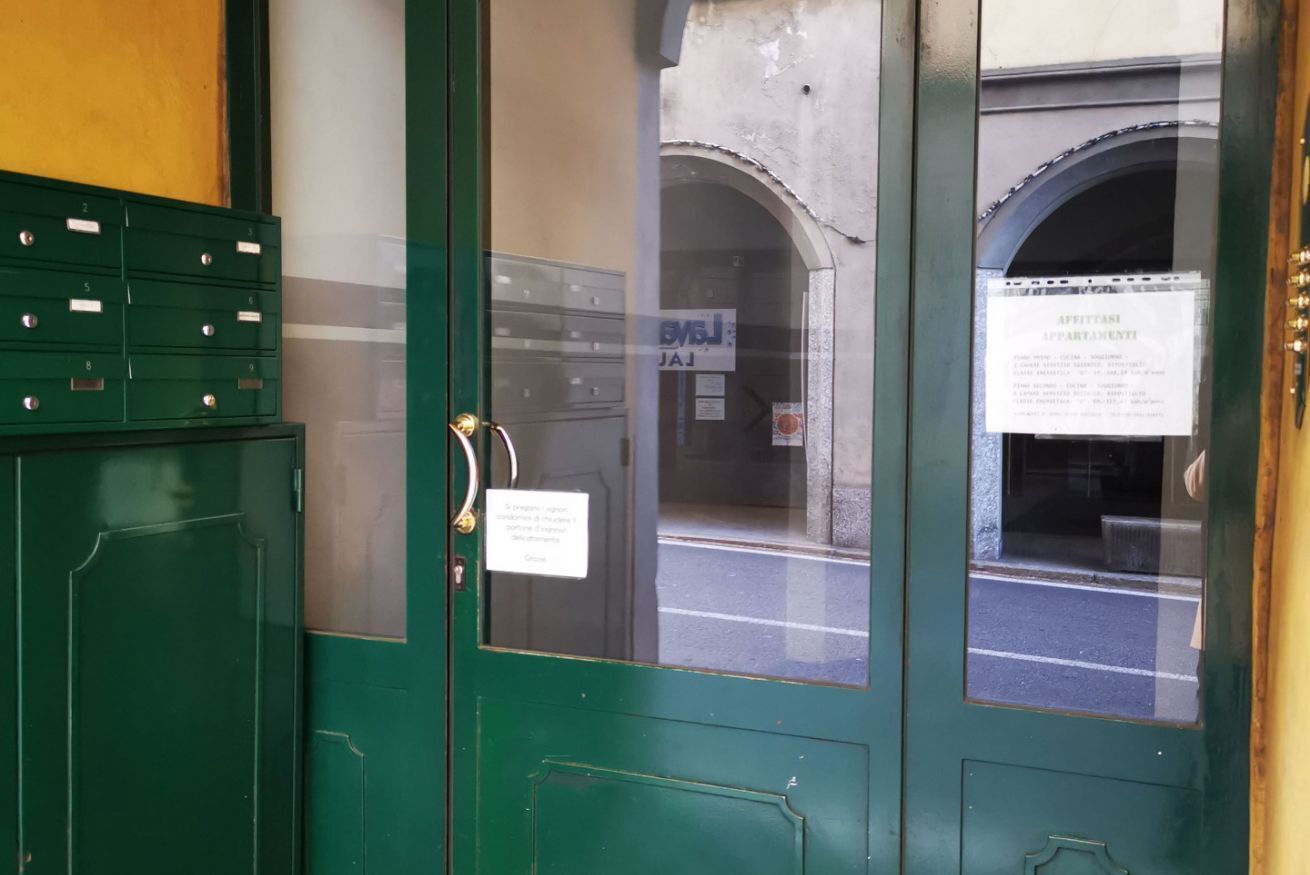 Eine grüne Tür mit einem Schild, das den Eingang zu einer Wohnung kennzeichnet.