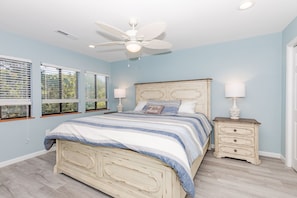 A bedroom with a bed, nightstands, a ceiling fan, and windows with blinds. - Always Beachin' - Custom Home in quiet Channelbend; Sleeps 10 (Surf City)