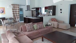 Una sala de estar moderna con un sofá, una mesa de centro y un comedor con una mesa y sillas.