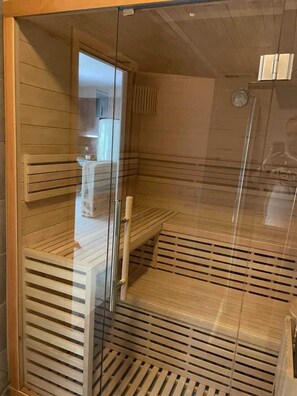 Relax in a sauna with a view, featuring wooden benches and a slatted floor.