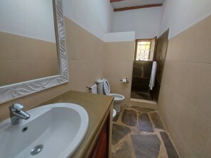 A bathroom with a large sink, toilet, and shower. - Sofia House (Malindi)