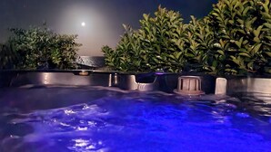 A hot tub with a moonlit night view, surrounded by lush greenery. - RELAX @ Sea La Vie KIAMA Million Dollar Views (Kiama)