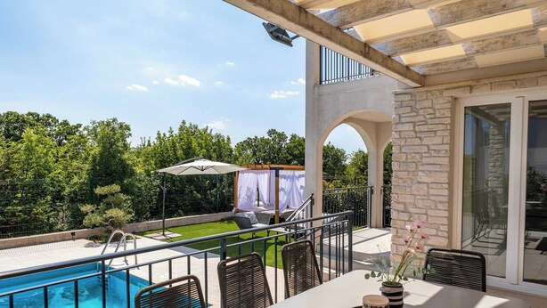 A poolside area with a table, chairs, and a covered seating area. - Villa Riviera (Sveti Lovrec Labinski)