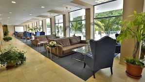 A spacious lobby with a long row of seating, large windows, and potted plants. - Hotel Sofia - All Inclusive (Varna)
