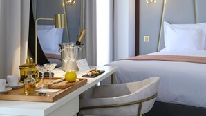 Una habitación de hotel con un escritorio ordenado, una cama y una lámpara moderna.
