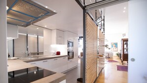 Una cucina moderna con mobili bianchi, un piano di lavoro nero e un tostapane rosso.