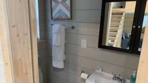 A bathroom with a toilet, sink, and towel rack. - Cozy Tiny Home in Heart of Big Sandy (Big Sandy)