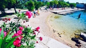 Une piscine à l’eau claire, entourée d’une terrasse en pierre et d’une végétation luxuriante.