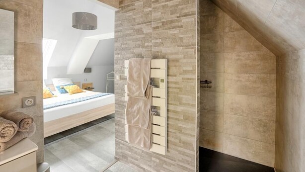 Un dormitorio moderno con una cama grande, un armario empotrado y un baño con toallero.