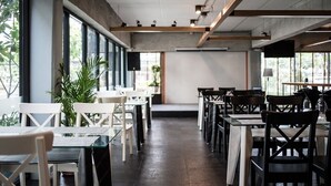 A modern restaurant interior with high ceilings, exposed beams, and large windows allowing natural light. Tables and chairs are arranged for dining. - Anda Bangkok Hotel (Bangkok)