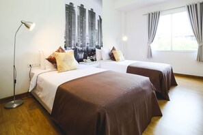 A hotel room with two beds, a large window with curtains, a wall-mounted artwork, and a floor lamp. - Anda Bangkok Hotel (Bangkok)