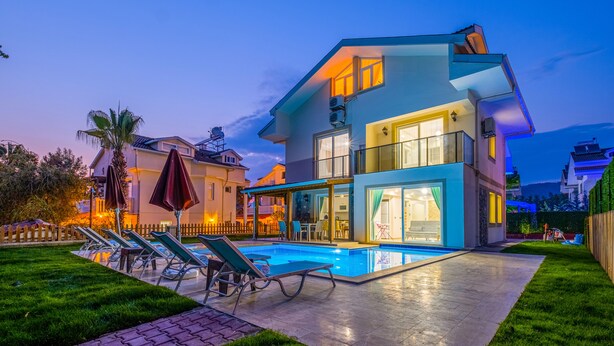 Une maison moderne à deux étages, dotée d’une piscine, d’un espace extérieur aménagé et d’un jardin bien entretenu.
