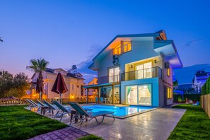 A modern two-story house with a swimming pool, outdoor seating, and a well-maintained garden. - Lilly Villa 1 (Fethiye)