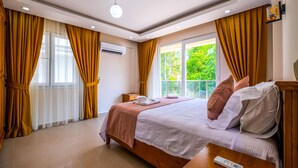 Une chambre à coucher avec un lit, une table de chevet, une télécommande et des rideaux.