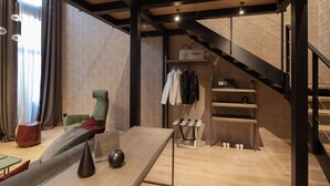 A modern living room with a sofa, a coffee table, and a staircase leading to a loft area. - Palazzo Pianca (Venice)