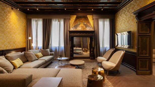 A luxurious living room with a sofa, armchairs, a coffee table, and a fireplace. - Palazzo Pianca (Venice)