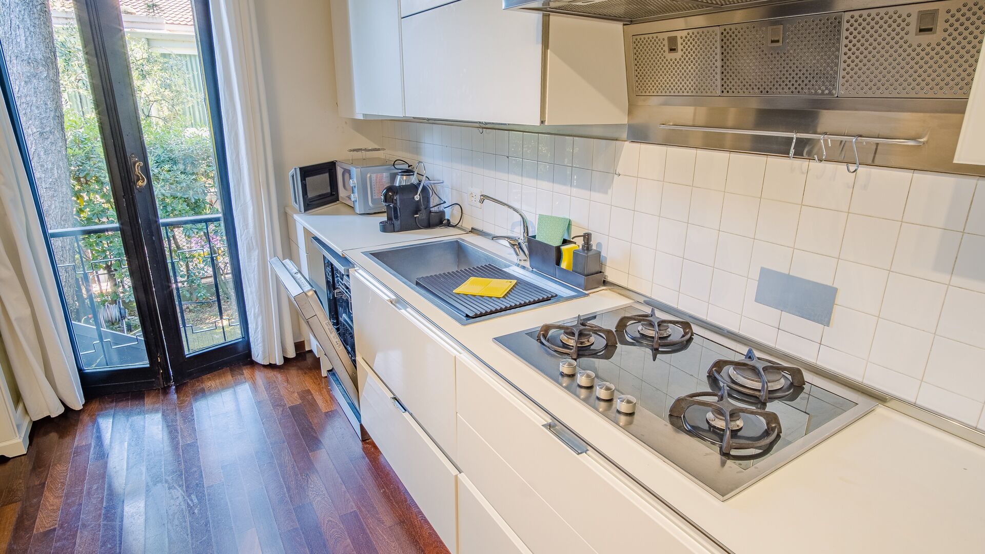 A modern kitchen with a gas stove, a microwave, and a sink.