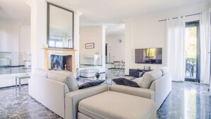 Ein modernes Wohnzimmer mit Kamin, Flachbildfernseher und Essbereich.