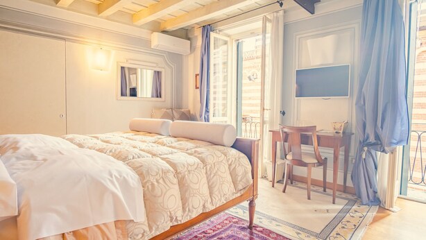 Un dormitorio con cama, escritorio y televisor.