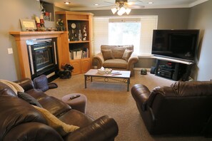 Cozy living room with a fireplace, TV, and comfortable seating for relaxation.