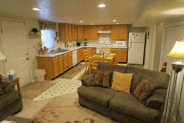 Cozy living space with a kitchenette, dining table, and comfortable sofa.