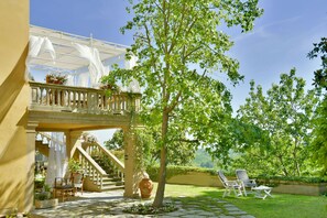 A covered outdoor area with a staircase, seating, and a tree. - VILLA WITH A POOL IN THE TUSCAN HILLS (CASCIANA TERME LARI)