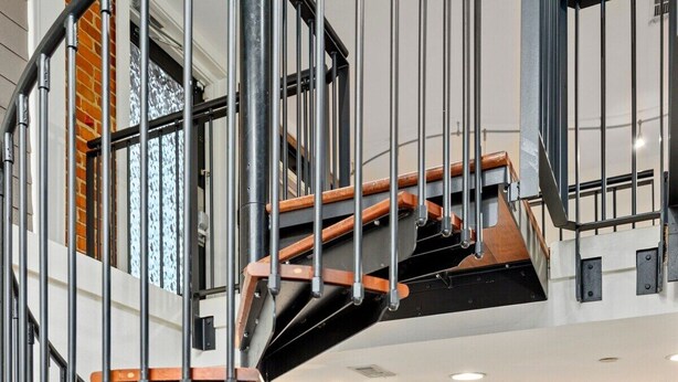Un intérieur moderne avec un escalier en colimaçon, un coin cuisine et un espace repas.